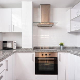 Imagen de cocina en U, actual, pequeña, con fregadero encastrado, armarios con paneles lisos, puertas de armario blancas, salpicadero blanco, electrodomésticos de acero inoxidable y encimeras grises