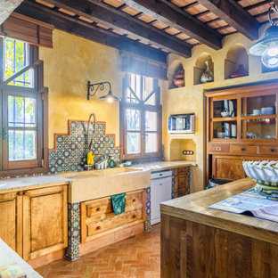 Ejemplo de cocina en U, mediterránea, con fregadero sobremueble, armarios con paneles con relieve, puertas de armario de madera oscura, salpicadero multicolor, suelo de baldosas de terracota, una isla, suelo rojo y encimeras beige