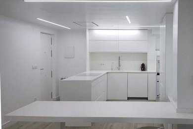 Foto de cocinas en L actual de tamaño medio abierta con armarios con paneles lisos, puertas de armario blancas y salpicadero blanco