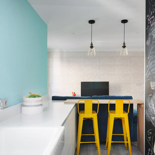 Foto de cocina de galera, actual, abierta, con fregadero sobremueble, armarios con paneles lisos, puertas de armario blancas, salpicadero azul, electrodomésticos blancos y península