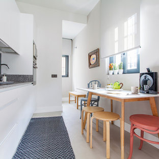 Imagen de cocina comedor lineal, escandinava, de tamaño medio, sin isla, con armarios con paneles lisos, puertas de armario blancas, encimera de granito, salpicadero azul, salpicadero de vidrio templado, electrodomésticos de acero inoxidable y suelo gris