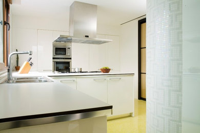 Modelo de cocinas en U contemporáneo de tamaño medio con puertas de armario blancas, suelo de baldosas de cerámica, península y suelo amarillo