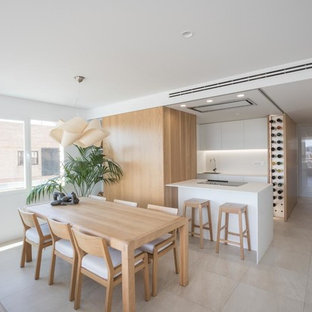 Imagen de cocina actual, abierta, con armarios con paneles lisos, puertas de armario blancas, salpicadero blanco, península, encimeras blancas, fregadero de un seno y suelo beige