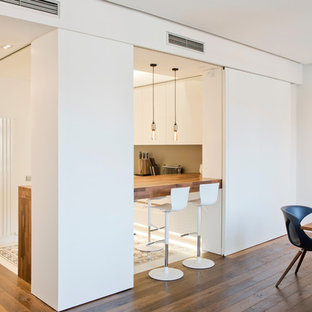 Photo of a large contemporary u-shaped open plan kitchen in Barcelona with a drop-in sink, flat-panel cabinets, white cabinets, quartz benchtops, brown splashback, panelled appliances, cement tiles, with island, multi-coloured floor and brown benchtop.
