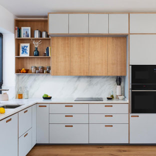Esempio di una cucina design di medie dimensioni con lavello sottopiano, ante in stile shaker, ante in legno chiaro, top in granito, paraspruzzi grigio, paraspruzzi in granito, elettrodomestici da incasso, pavimento in legno massello medio, nessuna isola, pavimento marrone e top grigio