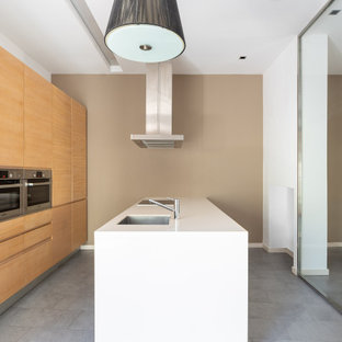 Diseño de cocina lineal, contemporánea, abierta, con fregadero integrado, armarios con paneles lisos, puertas de armario de madera oscura, encimera de cuarzo compacto, salpicadero blanco, salpicadero de metal, electrodomésticos de acero inoxidable, suelo de baldosas de cerámica, una isla, suelo gris y encimeras blancas