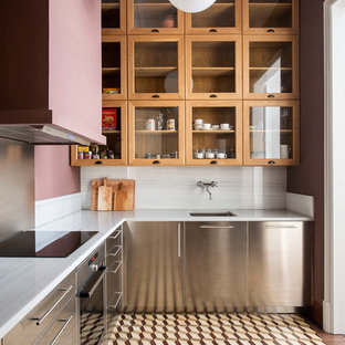Design ideas for a transitional l-shaped kitchen in Barcelona with an undermount sink, stainless steel cabinets, white splashback, stainless steel appliances, white benchtop, flat-panel cabinets, stone slab splashback and brown floor.