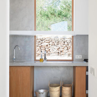 Ejemplo de cocina lineal y de obra, actual, grande, cerrada, sin isla, con encimera de cemento, fregadero integrado, armarios con paneles lisos, puertas de armario de madera oscura, salpicadero verde, salpicadero de azulejos de cemento, electrodomésticos de acero inoxidable y suelo de cemento