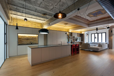 Idée de décoration pour une grande cuisine design avec un sol en bois brun.