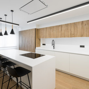 Diseño de cocina moderna, de tamaño medio, con armarios con paneles lisos, una isla, suelo marrón, encimeras blancas, puertas de armario blancas y suelo de baldosas de porcelana