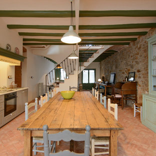Foto de cocina comedor lineal, mediterránea, grande, sin isla, con puertas de armario beige, suelo de baldosas de terracota, suelo rojo, salpicadero blanco, armarios con paneles empotrados y electrodomésticos negros