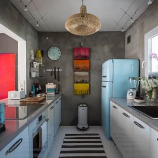 Inspiration for a small eclectic galley separate kitchen in Malaga with a drop-in sink, grey splashback, no island, flat-panel cabinets, white cabinets, solid surface benchtops, ceramic floors, coloured appliances and grey benchtop.