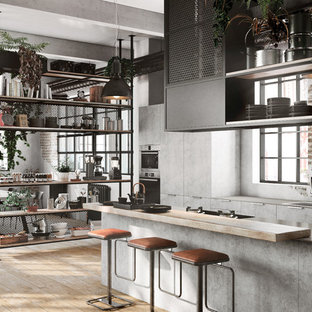 Modelo de cocina comedor de galera, urbana, con fregadero encastrado, armarios con paneles lisos, puertas de armario grises, suelo de madera clara, suelo beige y encimeras grises