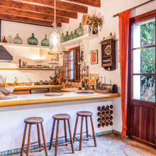 Diseño de cocina en U, mediterránea, con fregadero sobremueble, encimera de azulejos, salpicadero multicolor, península y encimeras multicolor