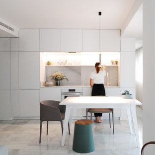 Foto de cocina lineal, moderna, pequeña, abierta, sin isla, con armarios con paneles lisos, puertas de armario blancas, encimera de mármol, salpicadero verde, salpicadero de mármol, electrodomésticos blancos, suelo de mármol, suelo gris y encimeras grises