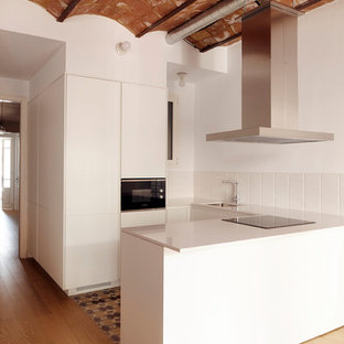 Ejemplo de cocina en U, mediterránea, de tamaño medio, con armarios con paneles lisos, puertas de armario blancas, encimera de cuarzo compacto, salpicadero blanco, salpicadero de azulejos de cerámica, electrodomésticos con paneles, suelo de baldosas de cerámica, península, suelo multicolor, encimeras blancas y fregadero bajoencimera