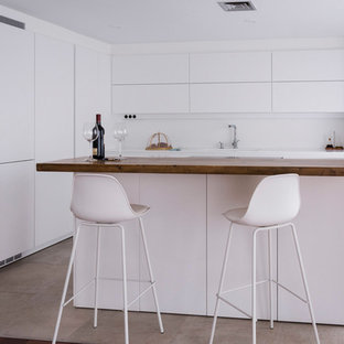 Diseño de cocina minimalista con fregadero integrado, armarios con paneles lisos, puertas de armario blancas, salpicadero blanco, una isla y encimeras blancas