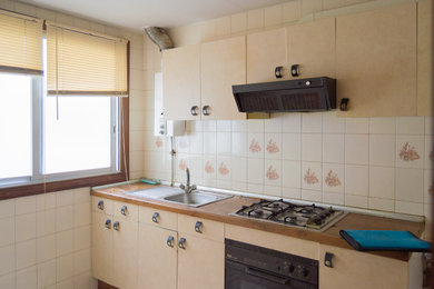 Foto de cocinas en L minimalista abierta con armarios con paneles lisos, puertas de armario grises, suelo laminado y suelo marrón