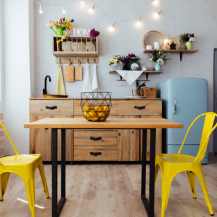 Foto de cocina comedor lineal, romántica, de tamaño medio, sin isla, con fregadero encastrado, armarios con paneles lisos, puertas de armario de madera oscura, encimera de madera, electrodomésticos de colores, suelo de madera clara, suelo beige y encimeras beige