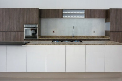 Diseño de cocina minimalista grande abierta con encimera de granito y una isla