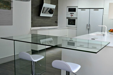 Idee per una cucina moderna di medie dimensioni con lavello a vasca singola, ante lisce, ante bianche, elettrodomestici bianchi e penisola