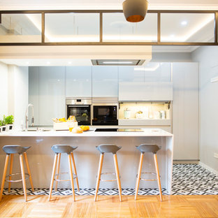 Imagen de cocina comedor lineal, contemporánea, grande, con fregadero de doble seno, puertas de armario grises, salpicadero metalizado, electrodomésticos de acero inoxidable, suelo de baldosas de cerámica, una isla, suelo multicolor y encimeras blancas