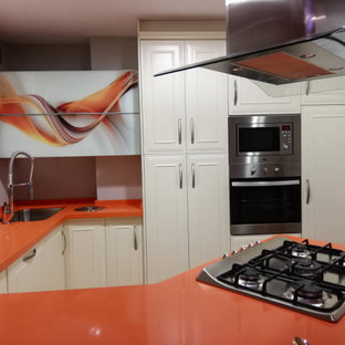 Photo of a small traditional u-shaped eat-in kitchen in Malaga with an undermount sink, beaded inset cabinets, white cabinets, quartz benchtops, stainless steel appliances, terrazzo floors, a peninsula, multi-coloured floor and orange benchtop.