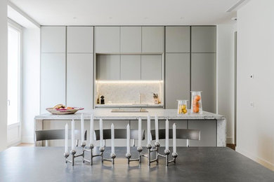 Imagen de cocina lineal actual de tamaño medio abierta con armarios con paneles lisos, puertas de armario grises y una isla