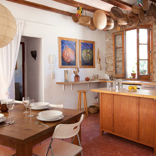 Photo of a mid-sized mediterranean galley eat-in kitchen in Barcelona with with island, flat-panel cabinets, light wood cabinets, wood benchtops, brown splashback, stainless steel appliances and ceramic floors.