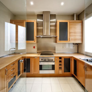 Photo of a mid-sized scandinavian u-shaped separate kitchen in Madrid with a drop-in sink, shaker cabinets, medium wood cabinets, wood benchtops, metallic splashback, metal splashback, no island, stainless steel appliances and ceramic floors.