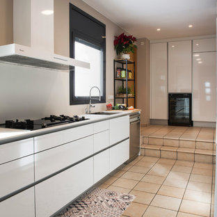Diseño de cocina en U, contemporánea, sin isla, con fregadero bajoencimera, armarios con paneles lisos, puertas de armario blancas, electrodomésticos de acero inoxidable, encimeras blancas, salpicadero blanco y suelo beige