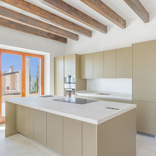 Imagen de cocina de galera, actual, con armarios con paneles lisos, electrodomésticos de acero inoxidable, una isla, puertas de armario beige, suelo beige y encimeras blancas
