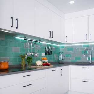 Imagen de cocina en L, contemporánea, de tamaño medio, abierta, sin isla, con fregadero bajoencimera, armarios con paneles lisos, puertas de armario blancas, suelo gris, encimeras grises, salpicadero multicolor, salpicadero de azulejos tipo metro y suelo de baldosas de porcelana