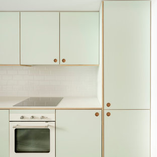 Design ideas for a small scandinavian single-wall open plan kitchen in Madrid with a drop-in sink, shaker cabinets, green cabinets, laminate benchtops, white splashback, ceramic splashback, stainless steel appliances, concrete floors, no island, grey floor and green benchtop.