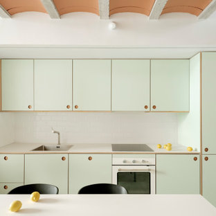 Modelo de cocina lineal, nórdica, pequeña, abierta, sin isla, con fregadero encastrado, armarios estilo shaker, puertas de armario verdes, encimera de laminado, salpicadero blanco, salpicadero de azulejos de cerámica, electrodomésticos de acero inoxidable, suelo de cemento, suelo gris y encimeras verdes