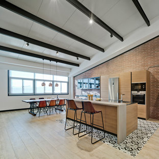 Foto de cocina comedor lineal, actual, grande, con armarios con paneles lisos, puertas de armario de madera oscura, suelo de madera clara, una isla, electrodomésticos de acero inoxidable y suelo beige