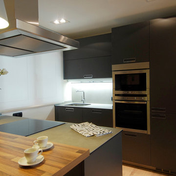 Decoración de cocina con muebles en negro y suelo laminado de madera