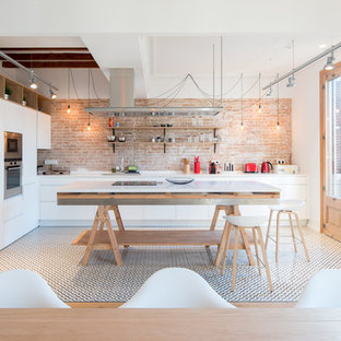 Modelo de cocina comedor actual, grande, con armarios con paneles lisos, puertas de armario blancas, encimera de mármol, suelo de baldosas de porcelana, una isla, fregadero bajoencimera, salpicadero de ladrillos, electrodomésticos de acero inoxidable y suelo multicolor