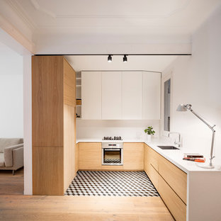 Photo of a mid-sized scandinavian u-shaped open plan kitchen in Barcelona with flat-panel cabinets, white splashback, stainless steel appliances, ceramic floors, no island, multi-coloured floor, a single-bowl sink, light wood cabinets and quartz benchtops.