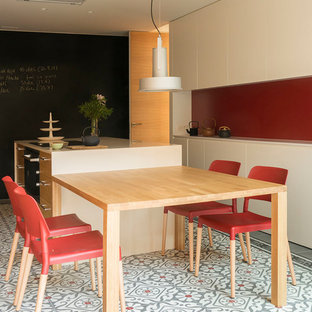 Foto de cocina lineal, actual, grande, cerrada, con armarios estilo shaker, puertas de armario de madera oscura, suelo de baldosas de cerámica, una isla, suelo multicolor y salpicadero rojo