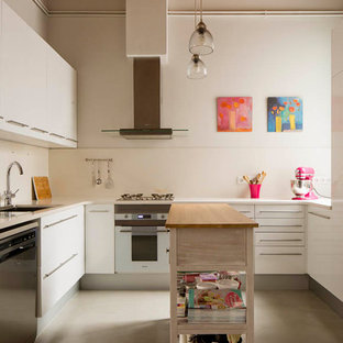 Imagen de cocina en U y de microcemento, urbana, de tamaño medio, cerrada, con puertas de armario blancas, suelo de cemento, una isla, suelo gris, salpicadero blanco, fregadero bajoencimera, armarios con paneles lisos, electrodomésticos de acero inoxidable y microcemento