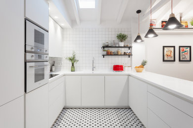 Diseño de cocinas en U abovedado actual con fregadero integrado, armarios con paneles lisos, puertas de armario blancas, salpicadero blanco, electrodomésticos blancos, península, suelo multicolor, encimeras blancas y vigas vistas