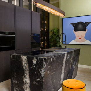 Imagen de cocina lineal, contemporánea, con encimera de cuarcita, una isla, armarios con paneles lisos, puertas de armario marrones, electrodomésticos negros, suelo de madera clara, suelo beige y encimeras multicolor