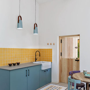 Diseño de cocina lineal, escandinava, de tamaño medio, sin isla, con fregadero encastrado, armarios con paneles lisos, puertas de armario turquesas, encimera de cuarzo compacto, suelo de baldosas de porcelana, suelo beige, encimeras grises, salpicadero amarillo y electrodomésticos con paneles