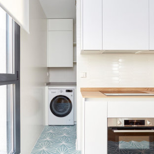Mittelgroße Moderne Küche mit Waschbecken, flächenbündigen Schrankfronten, weißen Schränken, Granit-Arbeitsplatte, Küchenrückwand in Weiß, Rückwand aus Keramikfliesen, weißen Elektrogeräten, Keramikboden, türkisem Boden und grauer Arbeitsplatte in Madrid