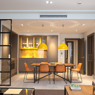 This is an example of a mid-sized contemporary l-shaped eat-in kitchen in Barcelona with flat-panel cabinets, grey cabinets, yellow splashback, ceramic splashback, light hardwood floors and no island.