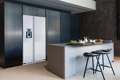 Foto de cocina minimalista con armarios con paneles lisos, puertas de armario negras y una isla