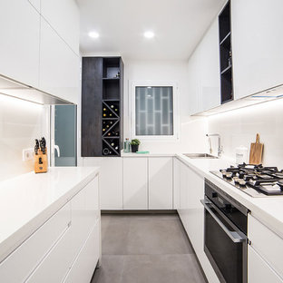Diseño de cocina en L, contemporánea, sin isla, con fregadero de doble seno, armarios con paneles lisos, puertas de armario blancas, salpicadero blanco, electrodomésticos negros, suelo gris y encimeras blancas