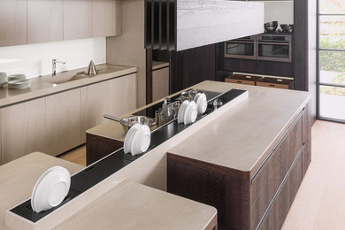 Ejemplo de cocina actual con salpicadero beige, electrodomésticos de acero inoxidable, suelo de madera clara, suelo marrón y encimeras beige
