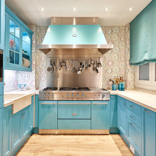 Foto de cocina en U, tradicional renovada, de tamaño medio, cerrada, con puertas de armario azules, salpicadero multicolor, electrodomésticos de acero inoxidable, suelo de madera clara y suelo beige